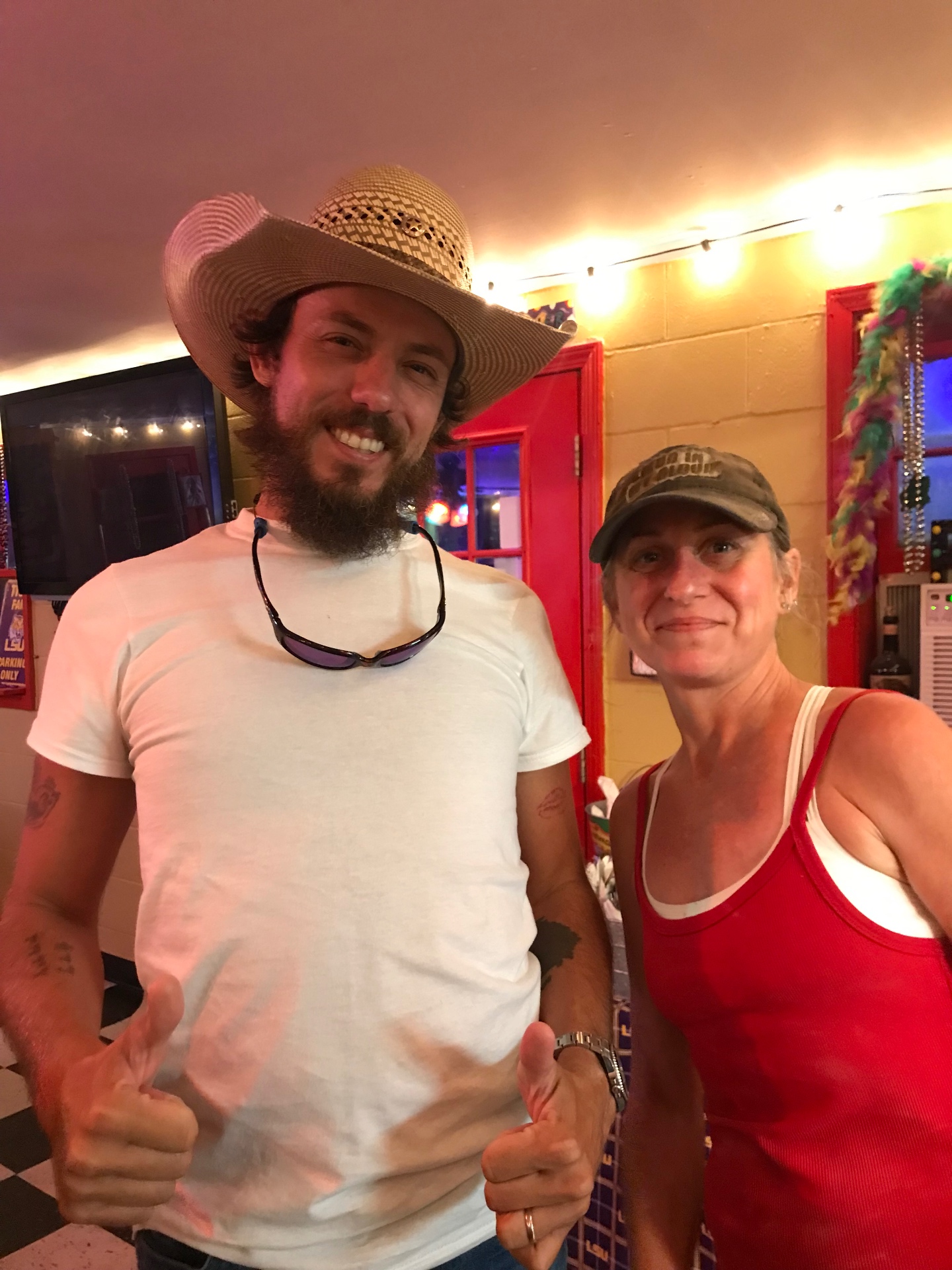 Cara with a guest in the restaurant, both giving a thumbs up