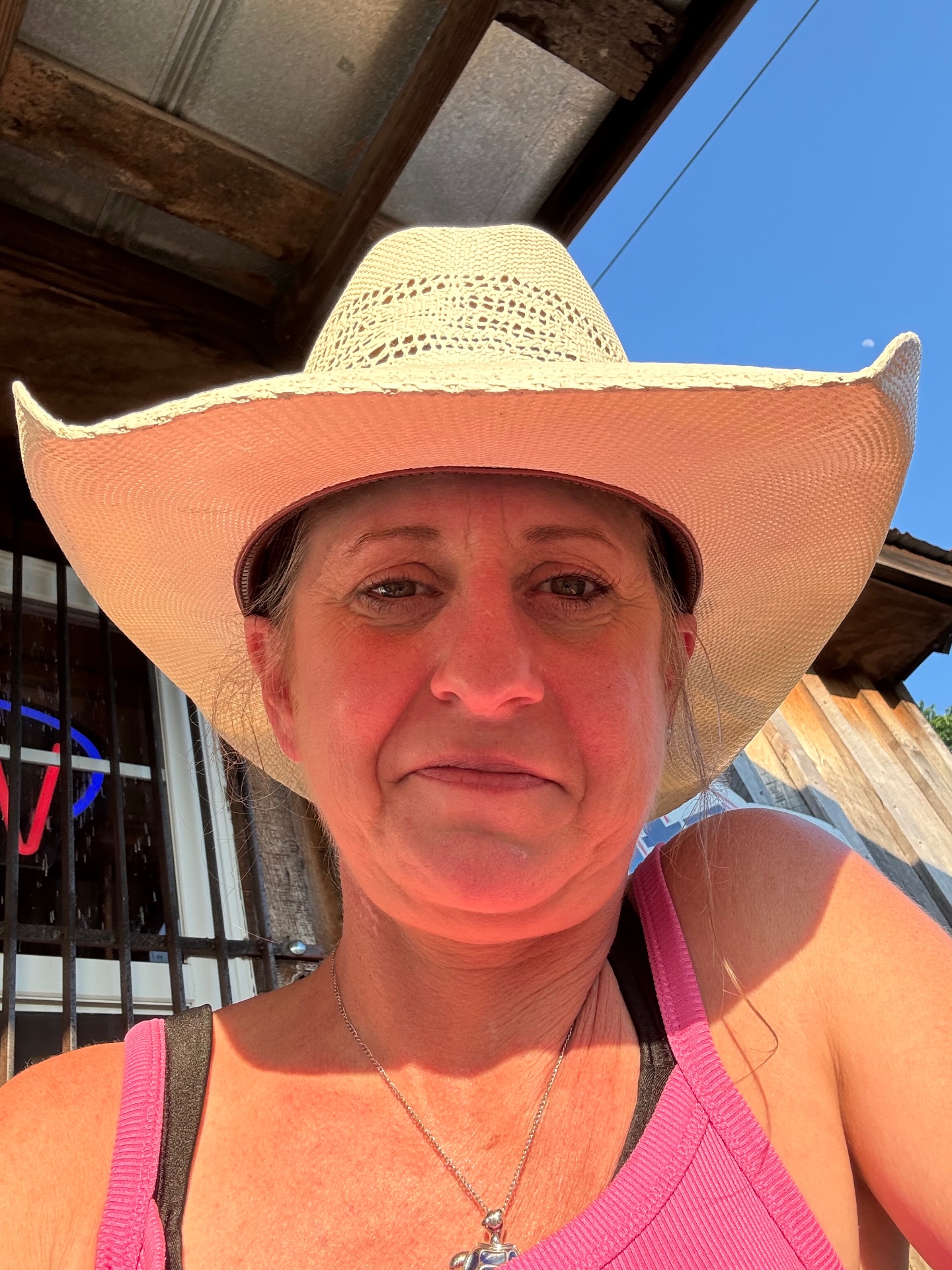 Cara in a straw cowboy hat outside a Nashville honky-tonk